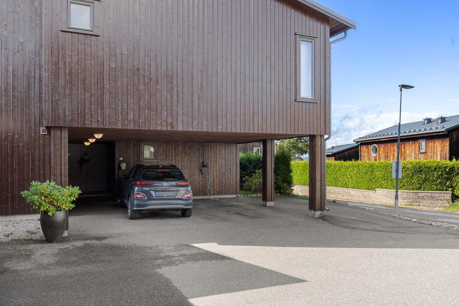 Biloppstillingsplass i carport. Leiligheten disponerer en stor utvendig bod. Galleribilde