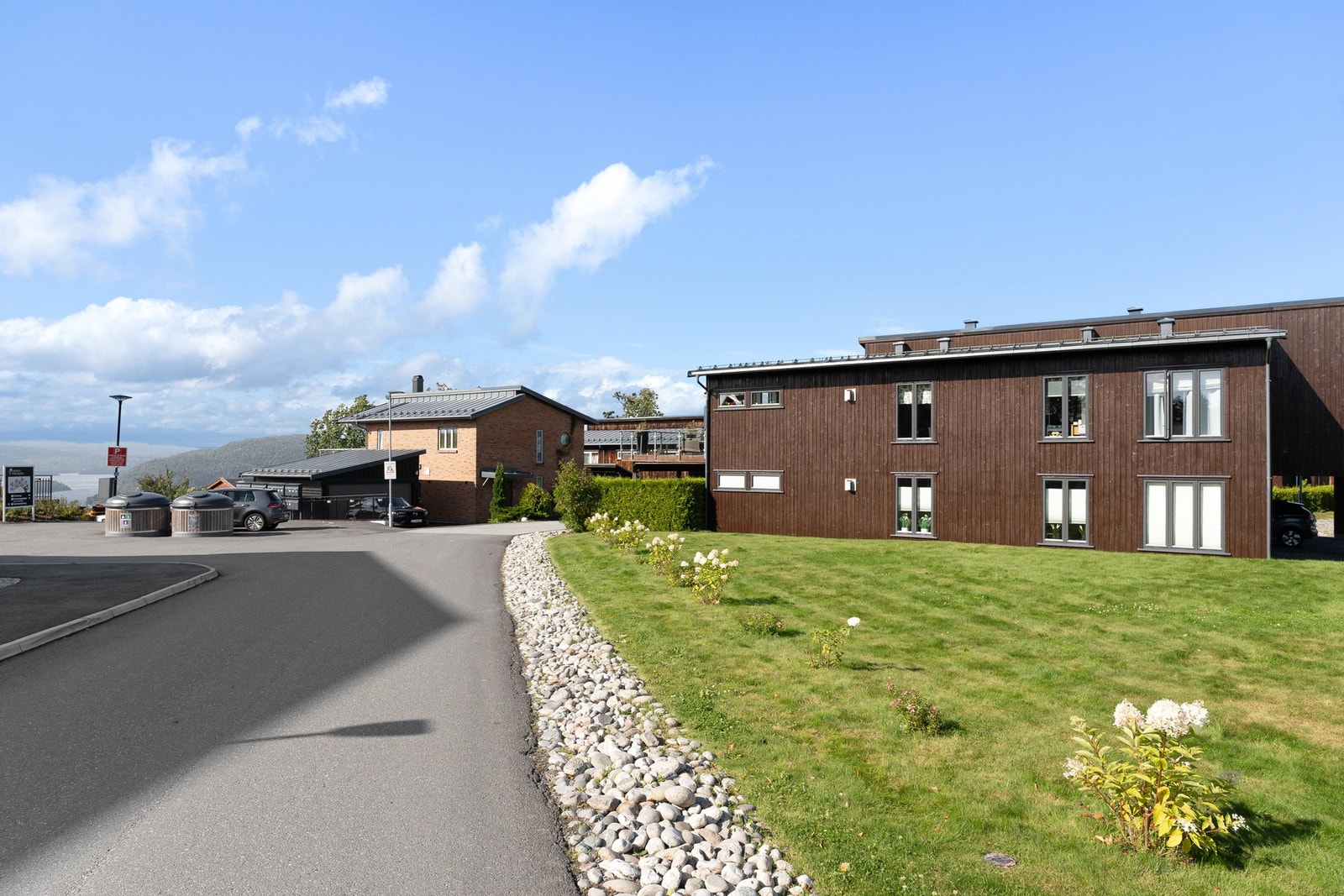 Felles tomt for borettslaget er opparbeidet med asfalterte biloppstillingsplasser, gressplen og diverse beplantning. Galleribilde