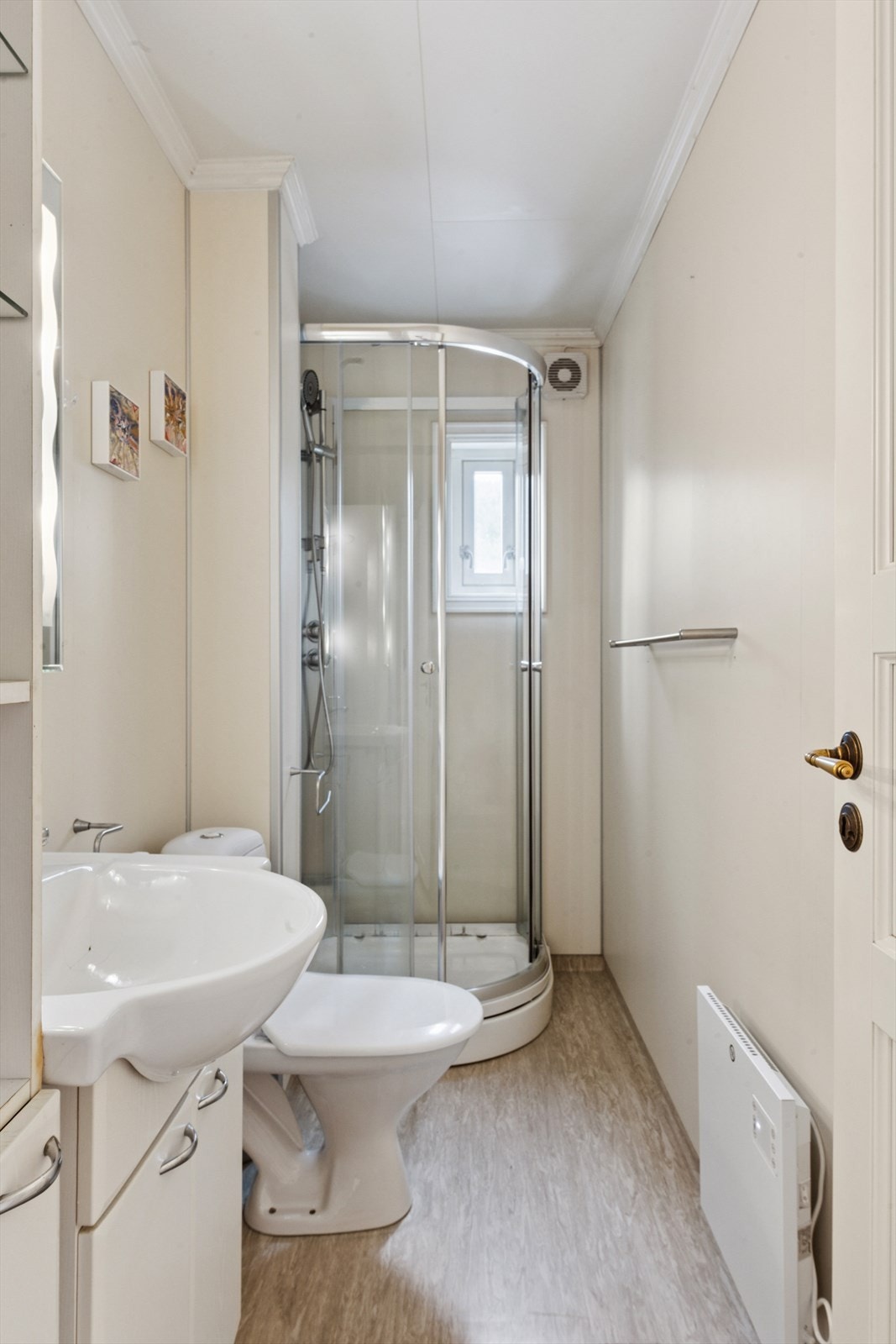 Bad med dusjkabinett, gulvstående toalett og lys baderomsinnredning. Galleribilde