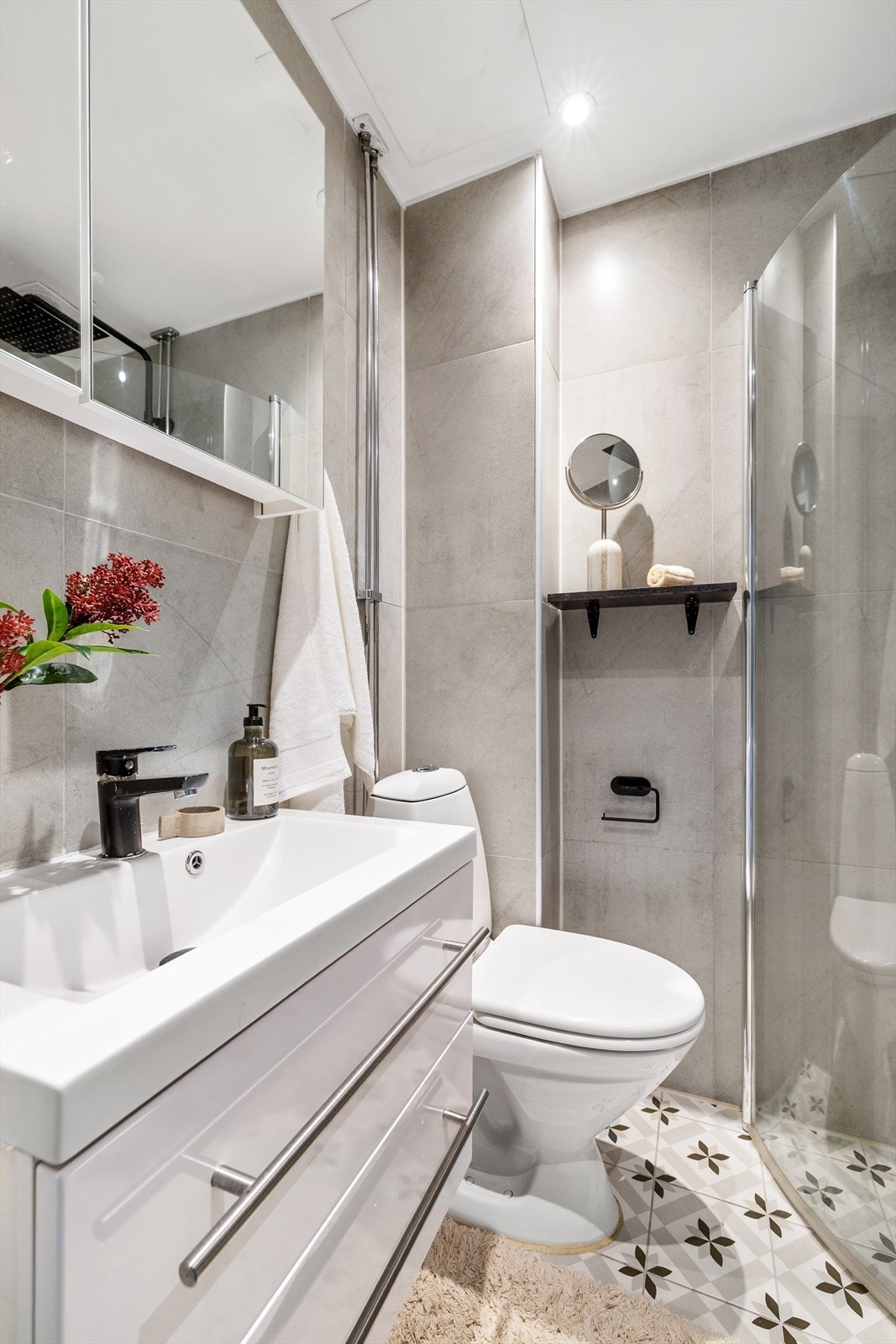 Videre har badet vegghengt toalett, dusj og dobbel servantinnredning med lyse fronter, speil og belysning. Galleribilde