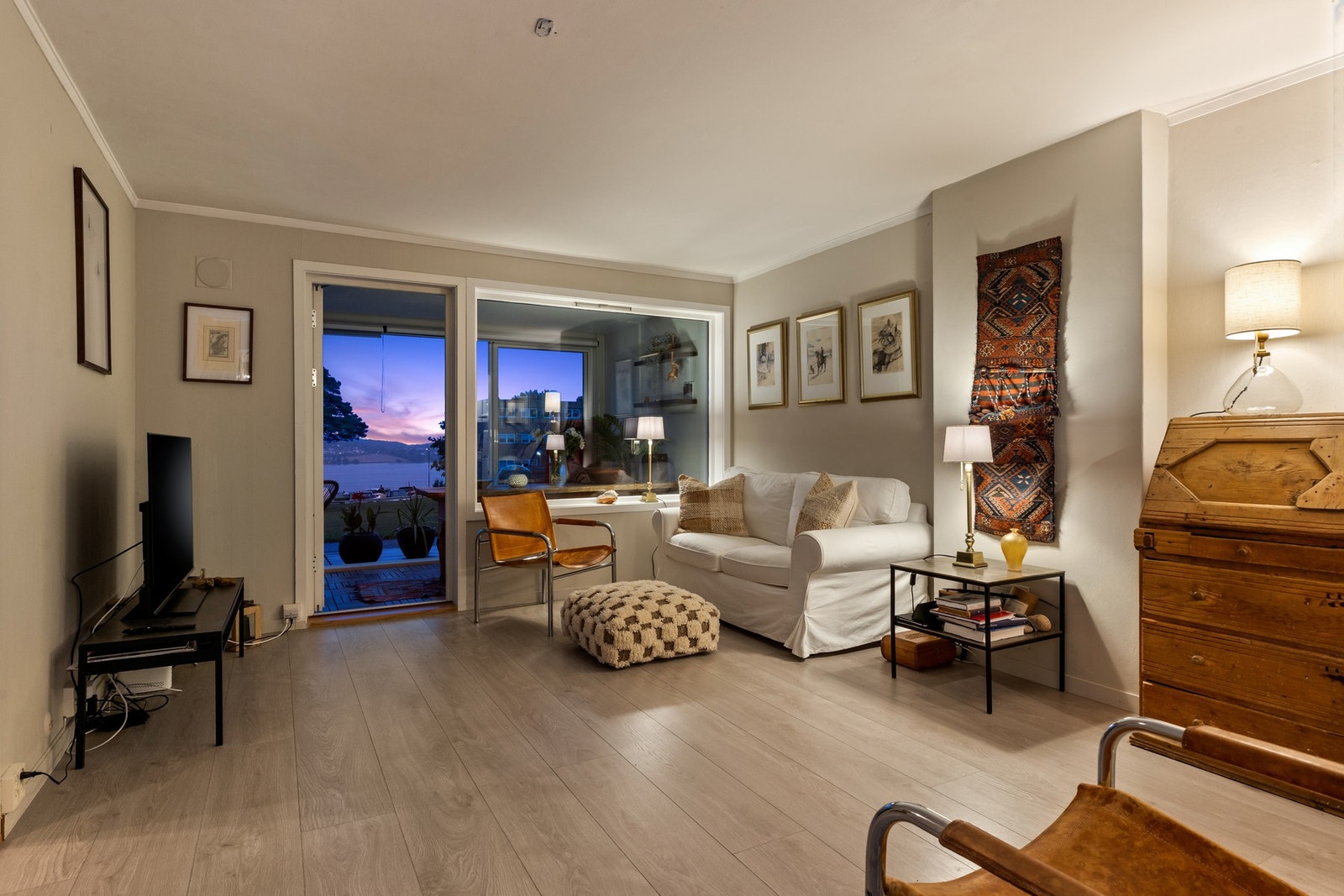 Med åpen dør ut til den innglassede balkongen utvider man stuen med flere ekstra kvadratmeter Galleribilde