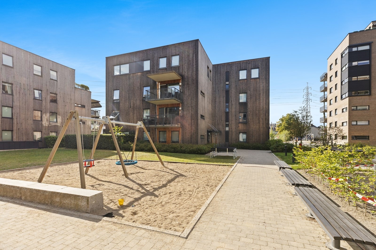 Felles bakgård med lekeapprater for de minste og flere sittegrupper. Galleribilde