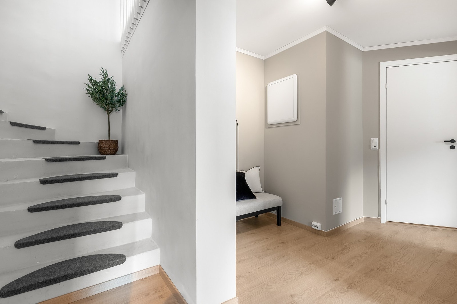 Entré/gang med parkettgulv og slette, lyse flater på vegger og i himling Galleribilde