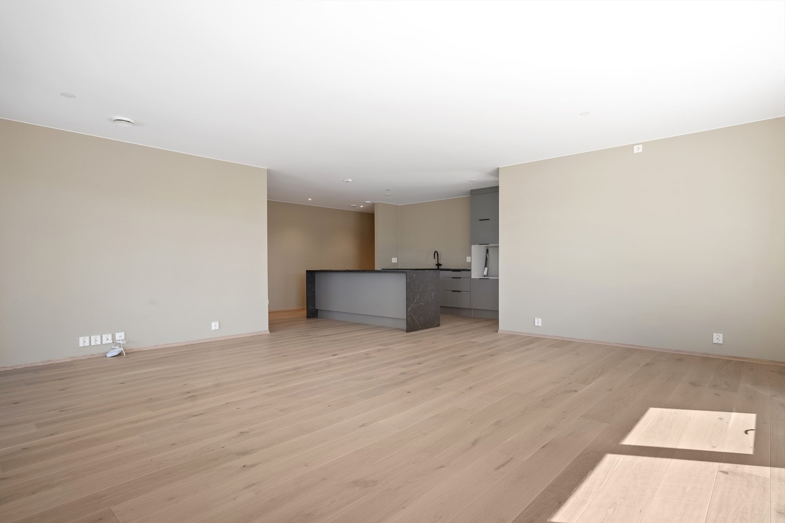 Åpen løsning mellom stue og kjøkken gir luftig romfølelse Galleribilde