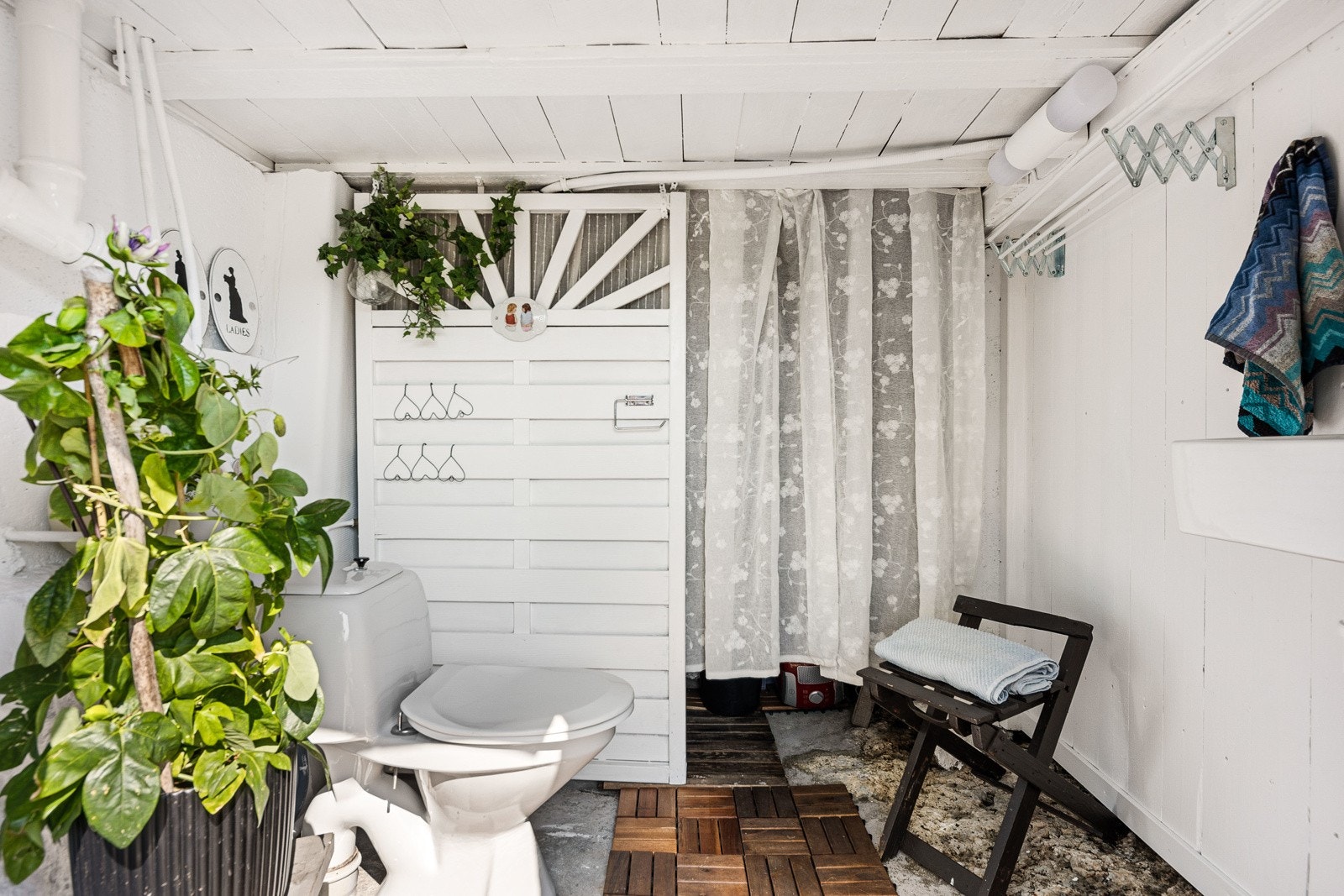 Toalettrommet i kjelleren har gulv i fjell og mur, veggmontert servant, et toalett og opplegg for vaskemaskin. Galleribilde