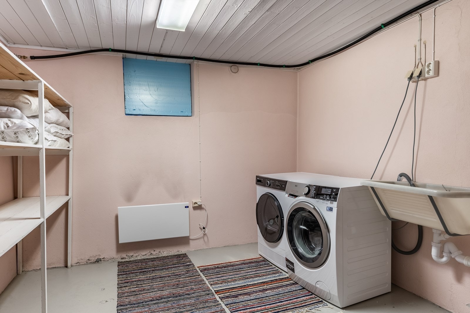 Enkel vaskeromsløsning i boligens underetasje. Vaskerommet er utstyrt med utslagsvask, varmtvannsbereder og opplegg for vaskemaskin Galleribilde