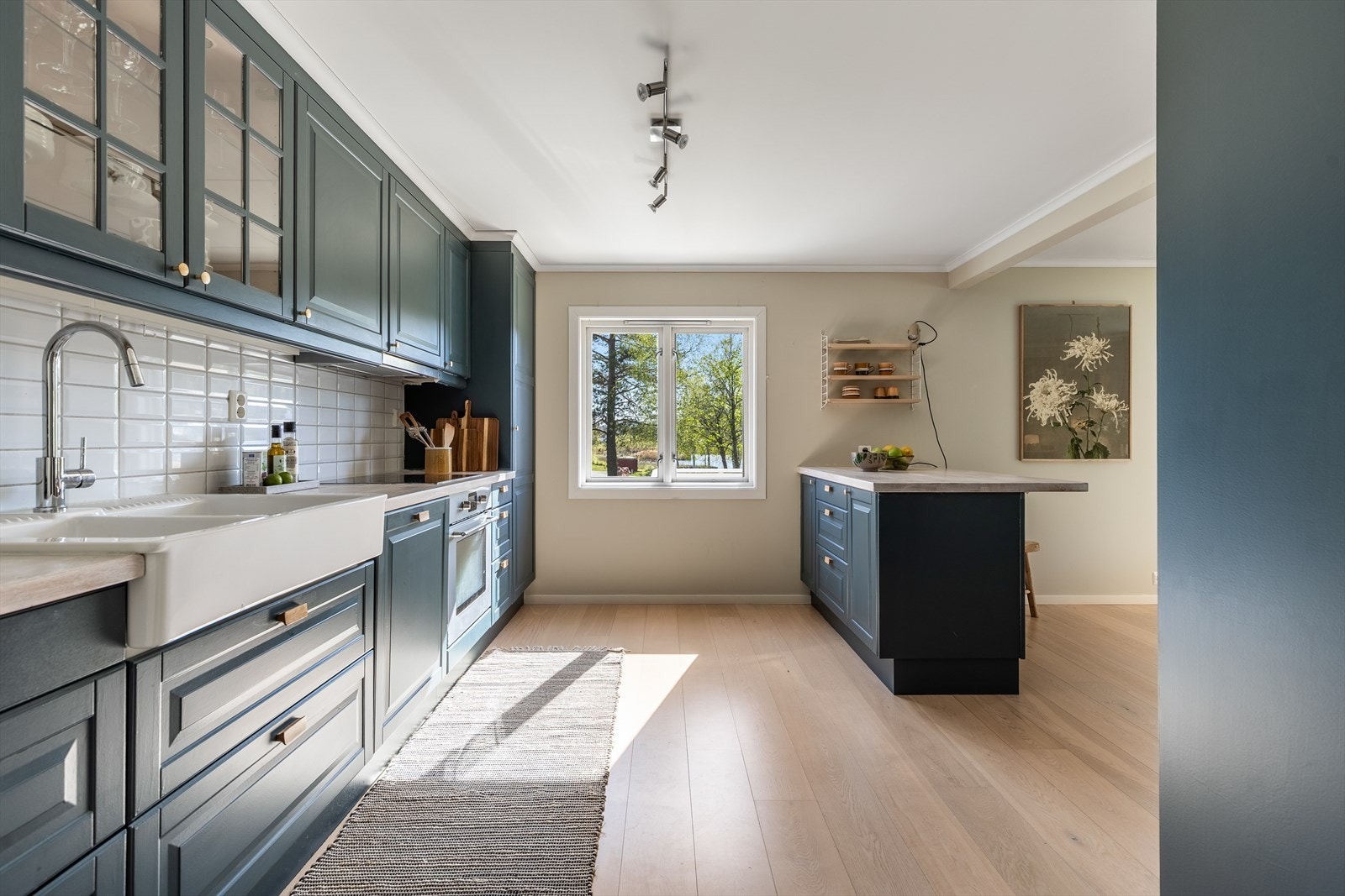 Fabrikkfremstilt kjøkkeninnredning med over og underskaper. Fronter i malt utførelse og benkplate i heltre Galleribilde