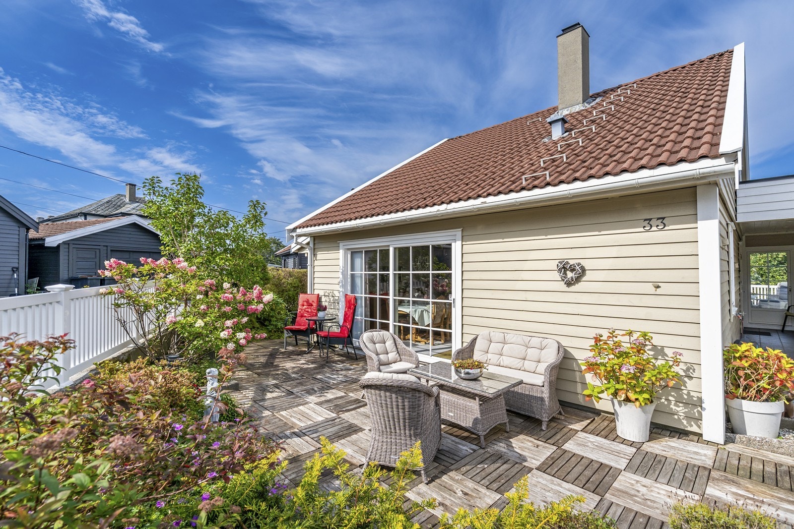 Eiendommen har et pent opparbeidet uteområde med frodig beplantning og flotte blomster. Galleribilde