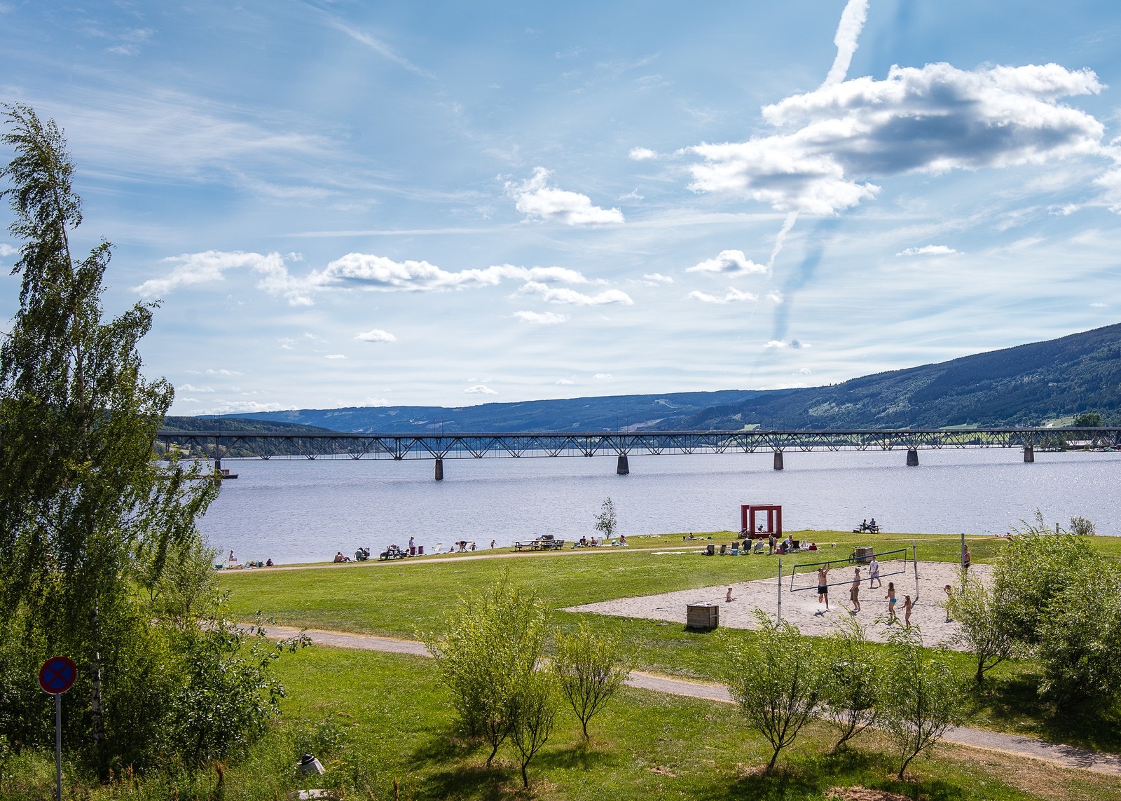 Strandpromenaden byr på grønne gressområder og sandvolleyballbane rett ved vannet - et perfekt sted for sommerdager med familie og venner. Galleribilde