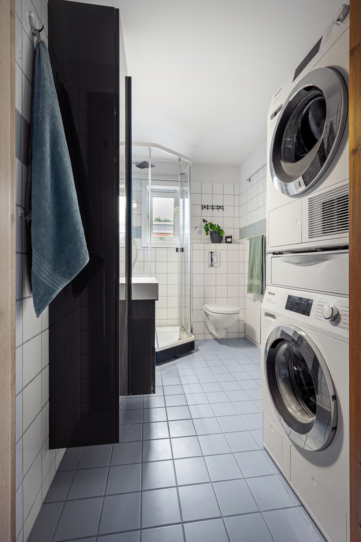 Badet er utstyrt med dusjhjørne, vegghengt do, servant samt løsning for vaskemaskin og tørketrommel. Galleribilde