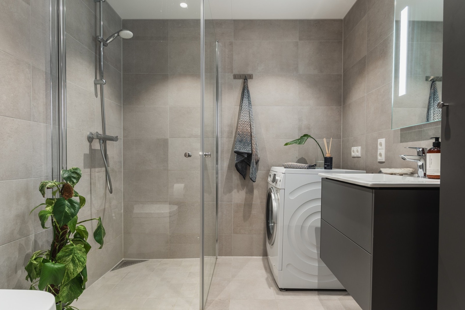 Badet er innredet i tidløse farger og det er rom for både vaskemaskin og tørketrommel. Galleribilde