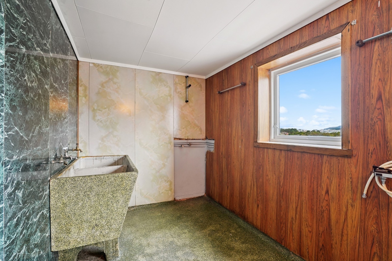 Innredet med servant, toalett, stort skyllekar med to kar og eldre opplegg med dusjanheng. Rommet er byggemeldt som rom for sykler og vaskerom (søknadspliktig bruksendring). Galleribilde