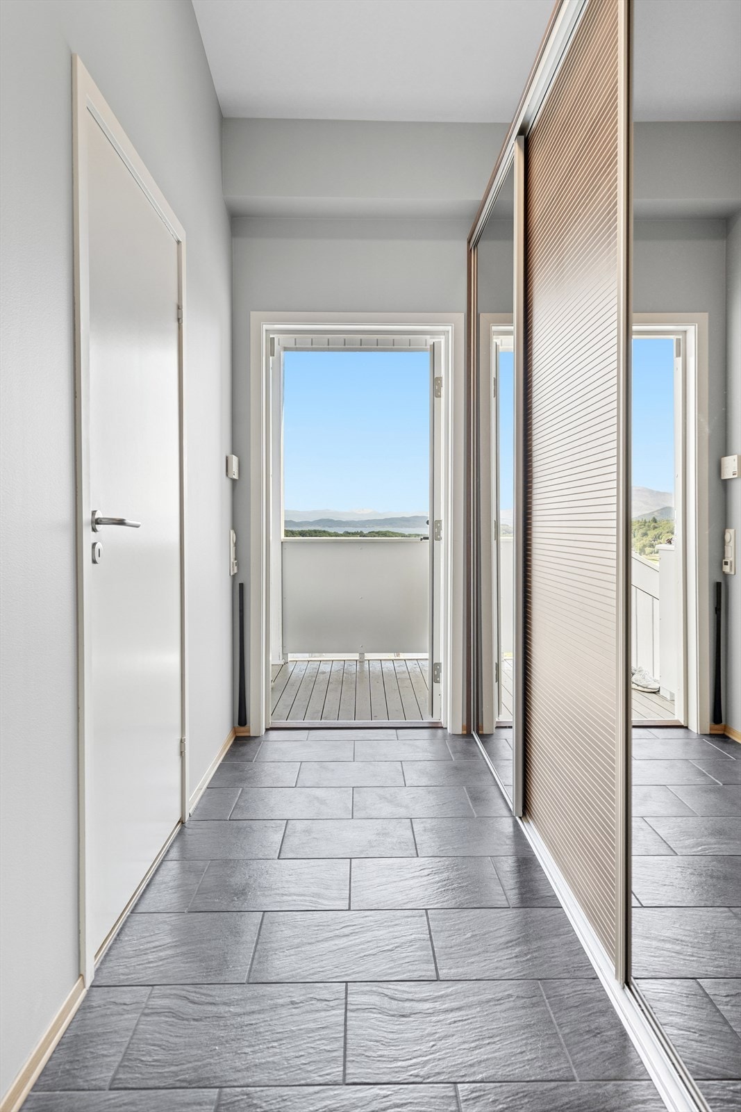 Du ønskes velkommen inn i en flislagt entrè utstyrt med gulvvarme og en romslig skyvedørsgarderobe Galleribilde