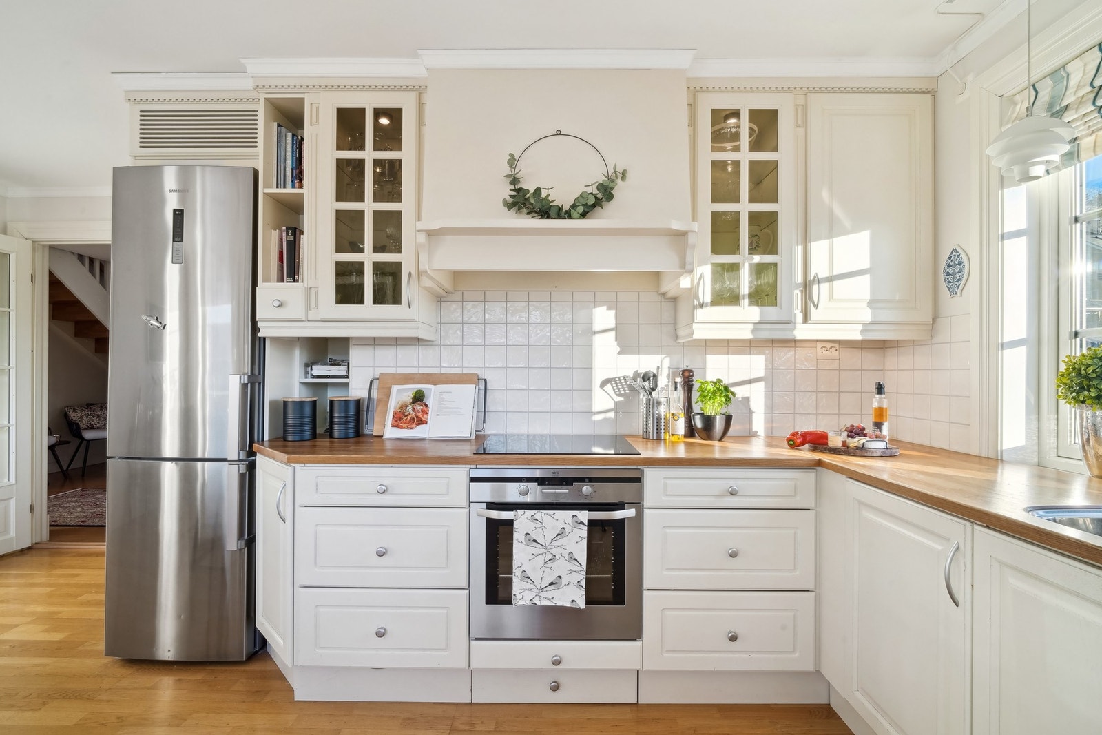 Hvite profilerte fronter og fliser på vegg over heltre 30 mm eik benkeplate. Galleribilde