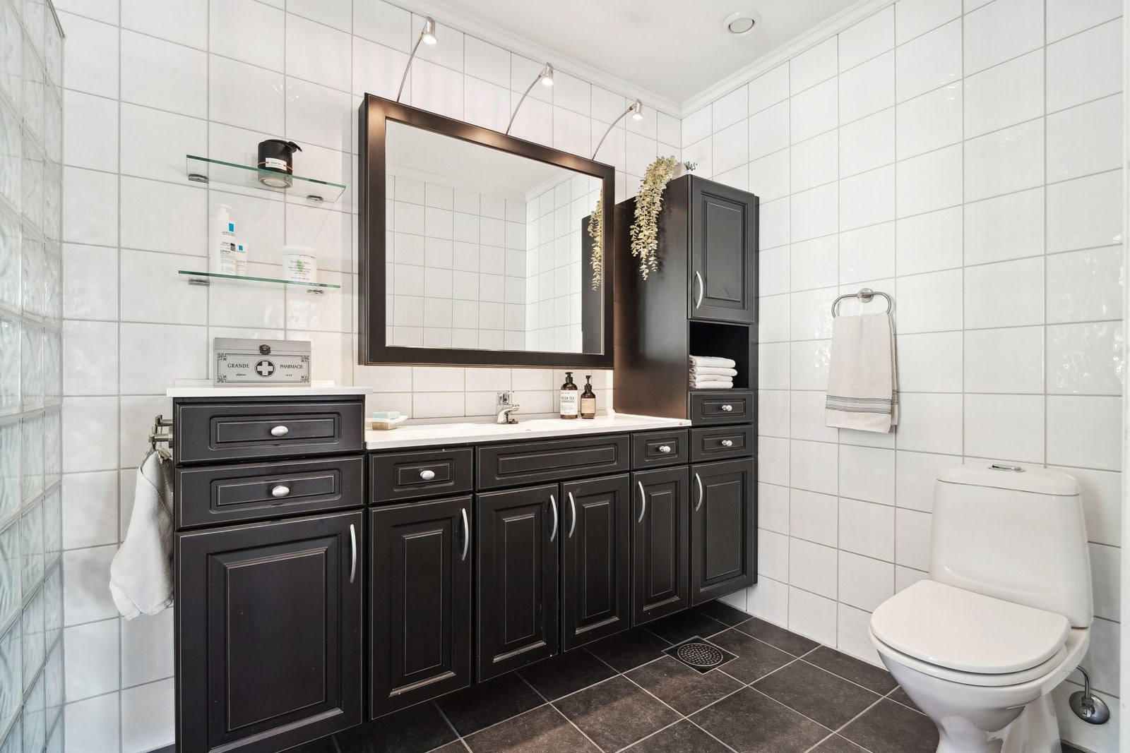 Badet er innredet med dusjhjørne med vegg av glassbyggerstein og glassdør, toalett - Galleribilde