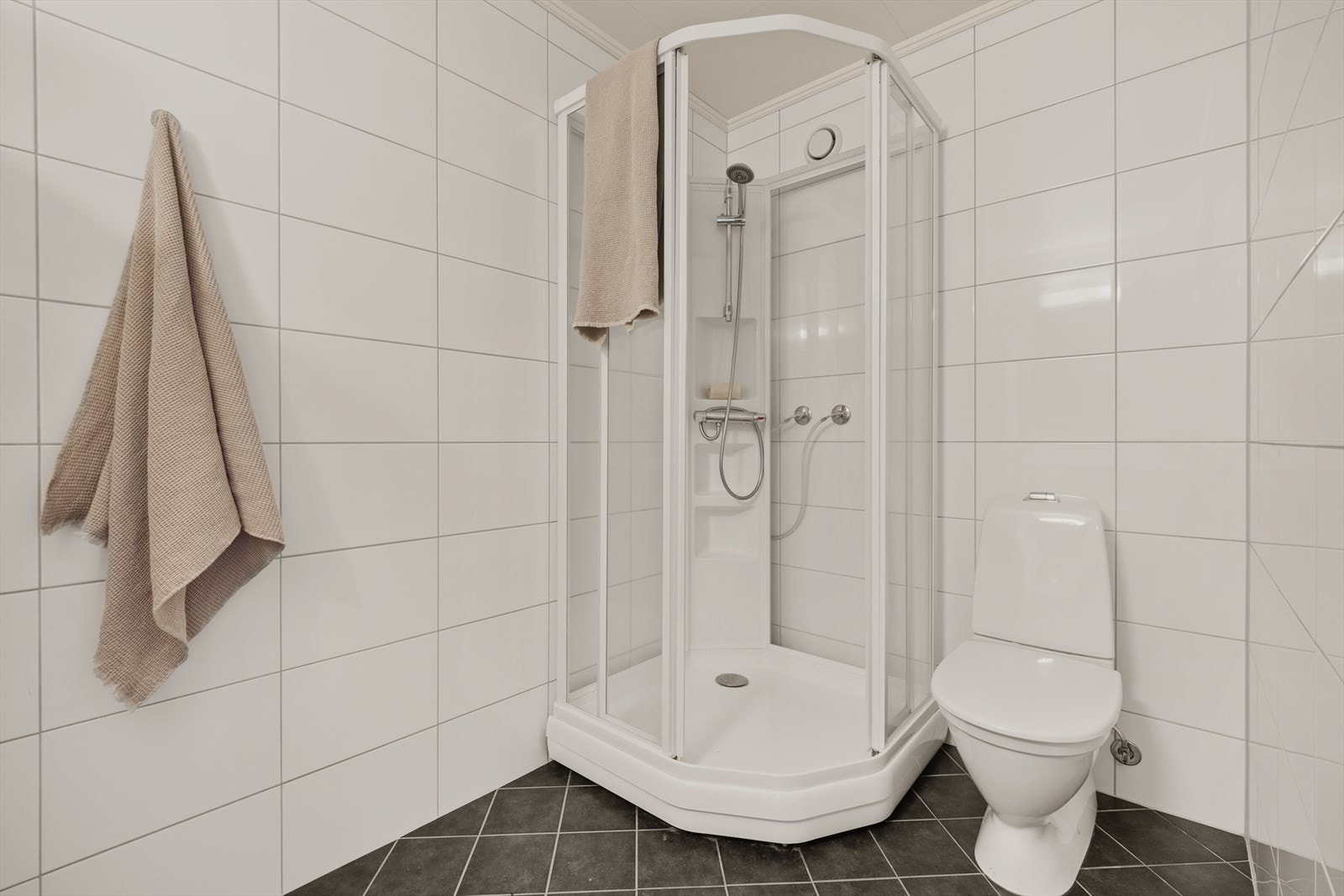 Innredningen består av servantskap med nedfelt servant, speil med lysarmatur over og gulvmontert klosett. Det er montert dusjkabinett. Galleribilde