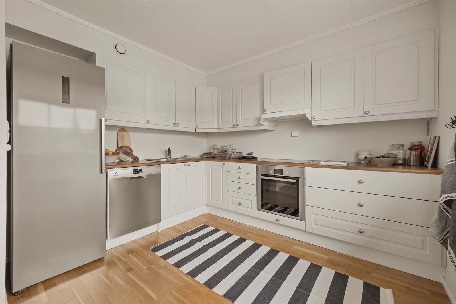 Innredningen er fra byggeåret 2011 og består av klassiske, hvite profilerte fronter. Over- og underskap gir godt med oppbevaringsplass, og det er montert lys under overskapene for bedre arbeidslys. Galleribilde