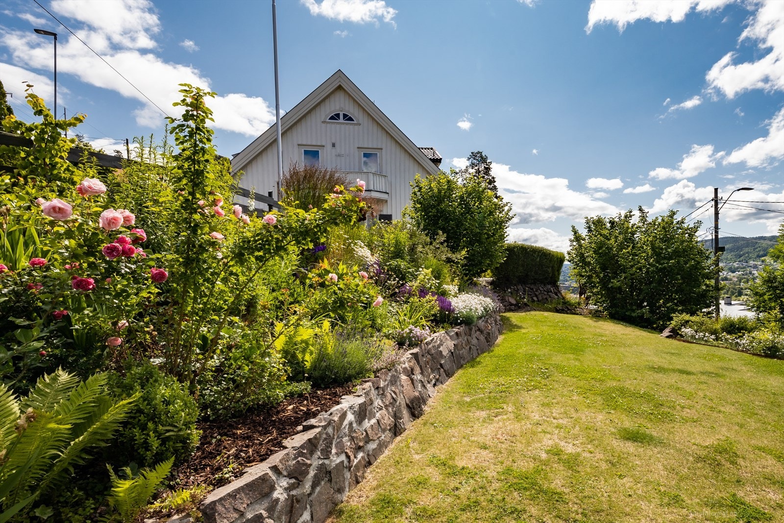 Idyllisk blomsterbed og uteområde. Galleribilde
