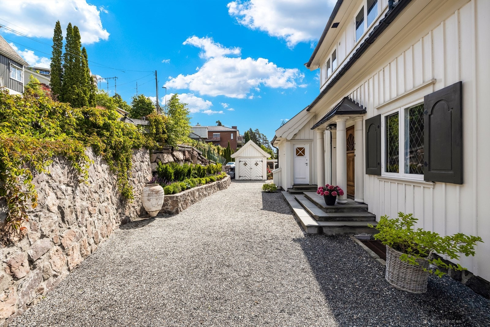 Eiendommen er svært pen opparbeidet med stor, gruset gårdsplass og støttemurer i naturstein. Galleribilde