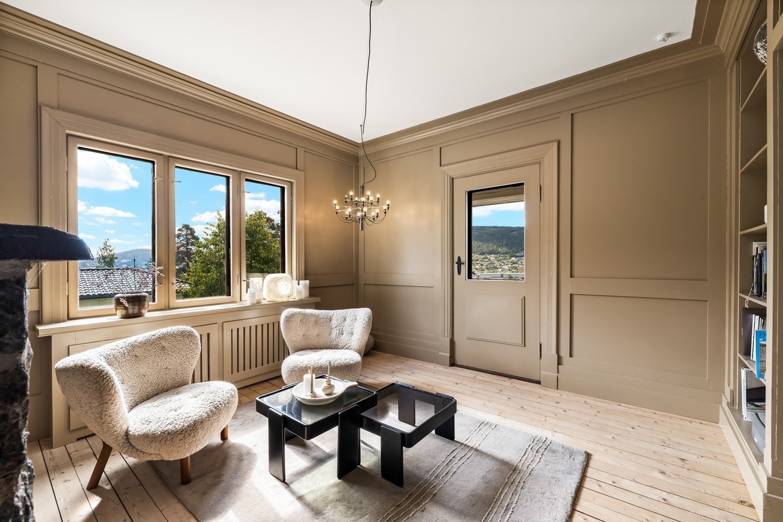 Her ble det i 2021 installert en moderne peisinnsats, og rommet har i tillegg en plassbygd bokhylle fra samme år - et perfekt sted for ro og lesetid. Galleribilde