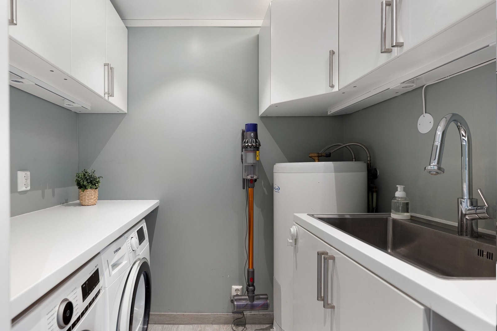 Dette vaskerommet, med adkomst fra entreen, er en drøm for alle barnefamilier! Innredningen har masse oppbevaringsplass og det er opplegg for vaskemaskin og tørketrommel. Galleribilde