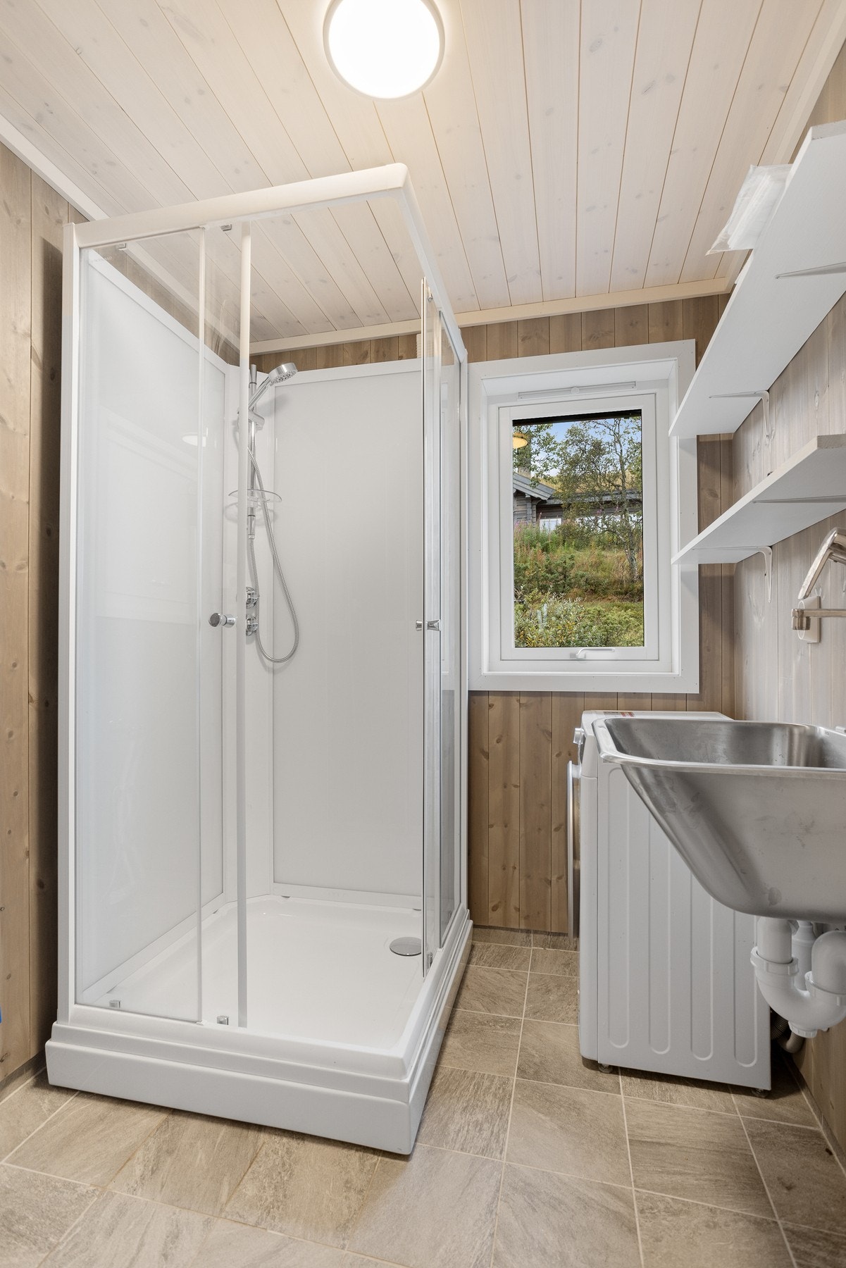 Praktisk vaskerom som inneholder opplegg til vaskemaskin, VV tank på 200 liter, skyllekar i stål og dusjkabinett Galleribilde