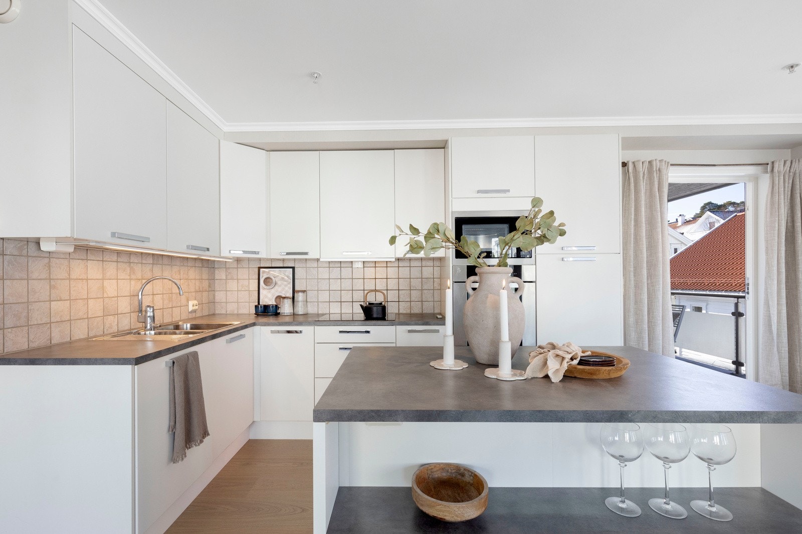 Nydelig kjøkkeninnredning med slett front, med grå laminert benkeplate. Galleribilde