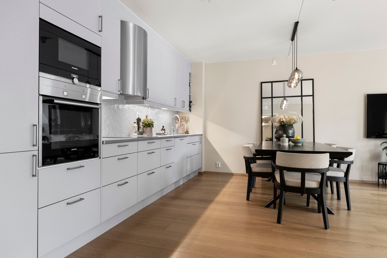 Innredningen har glatte fronter og en slitesterk laminat benkeplate, med planlimt oppvaskkum og elegante fliser over benk. Galleribilde