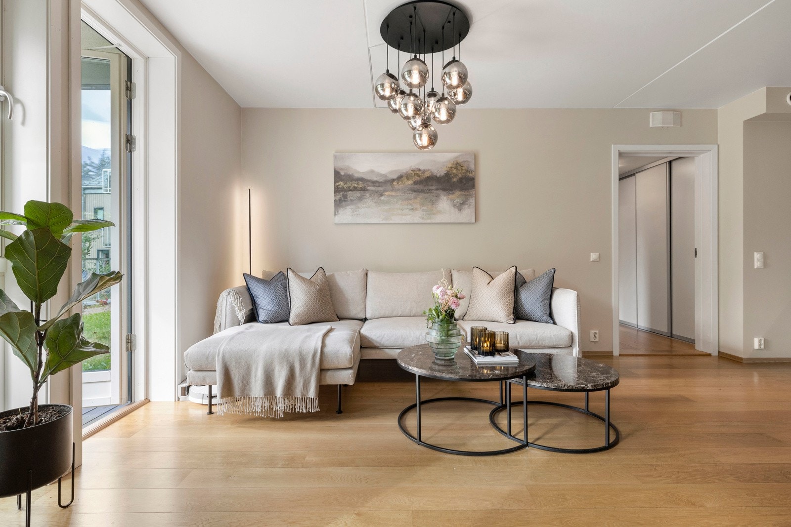 Stuen oppleves som lys og luftig, takket være store vindusflater som slipper inn naturlig lys og gir utsikt til grøntområder. Galleribilde