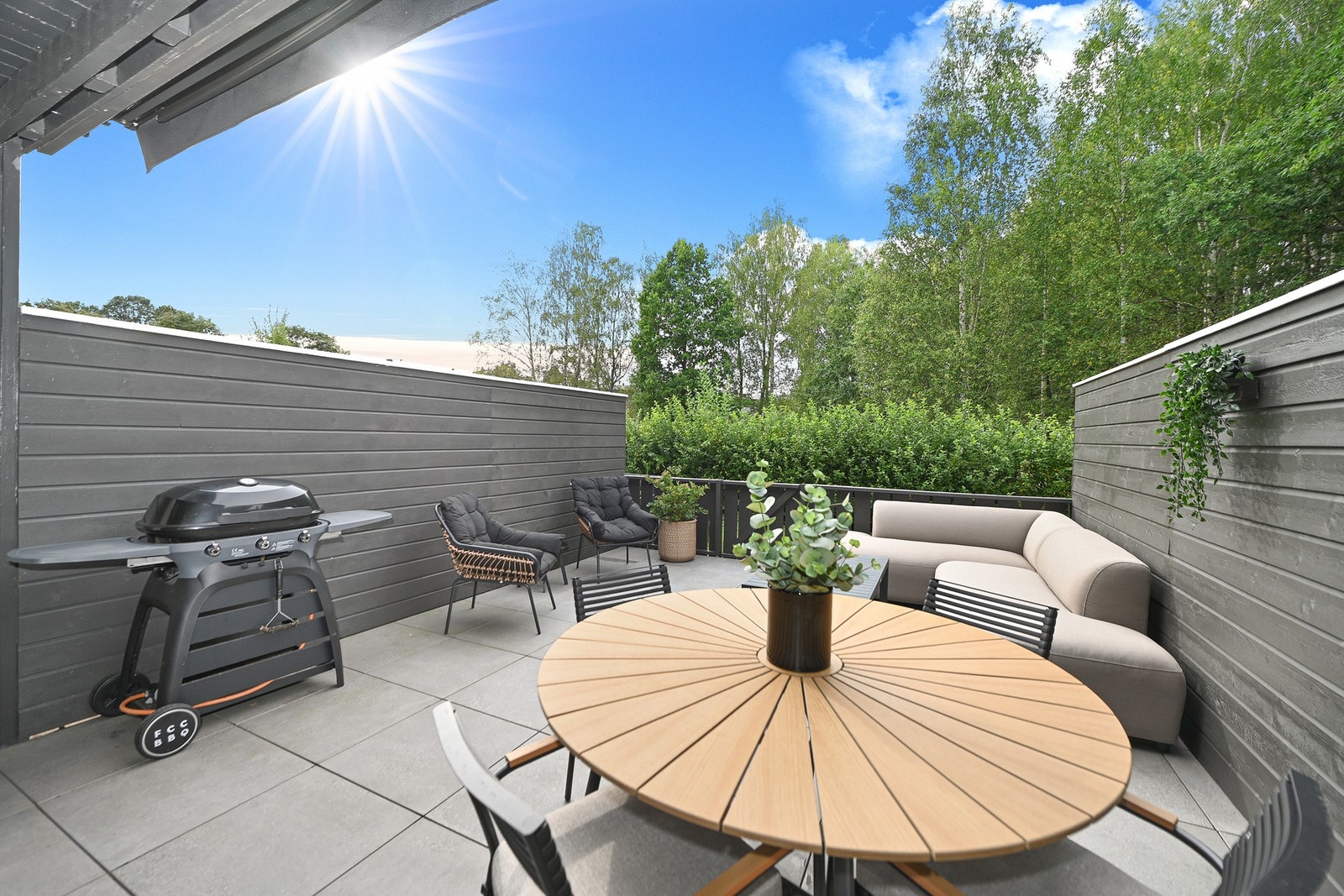 Terrassen ble bygget ut og fornyet i 2025 med flisheller som er en elegant løsning med enkel vedlikehold. Store deler av sommerhalvåret står døren oppe og terrassen blir som et ekstra rom. Galleribilde