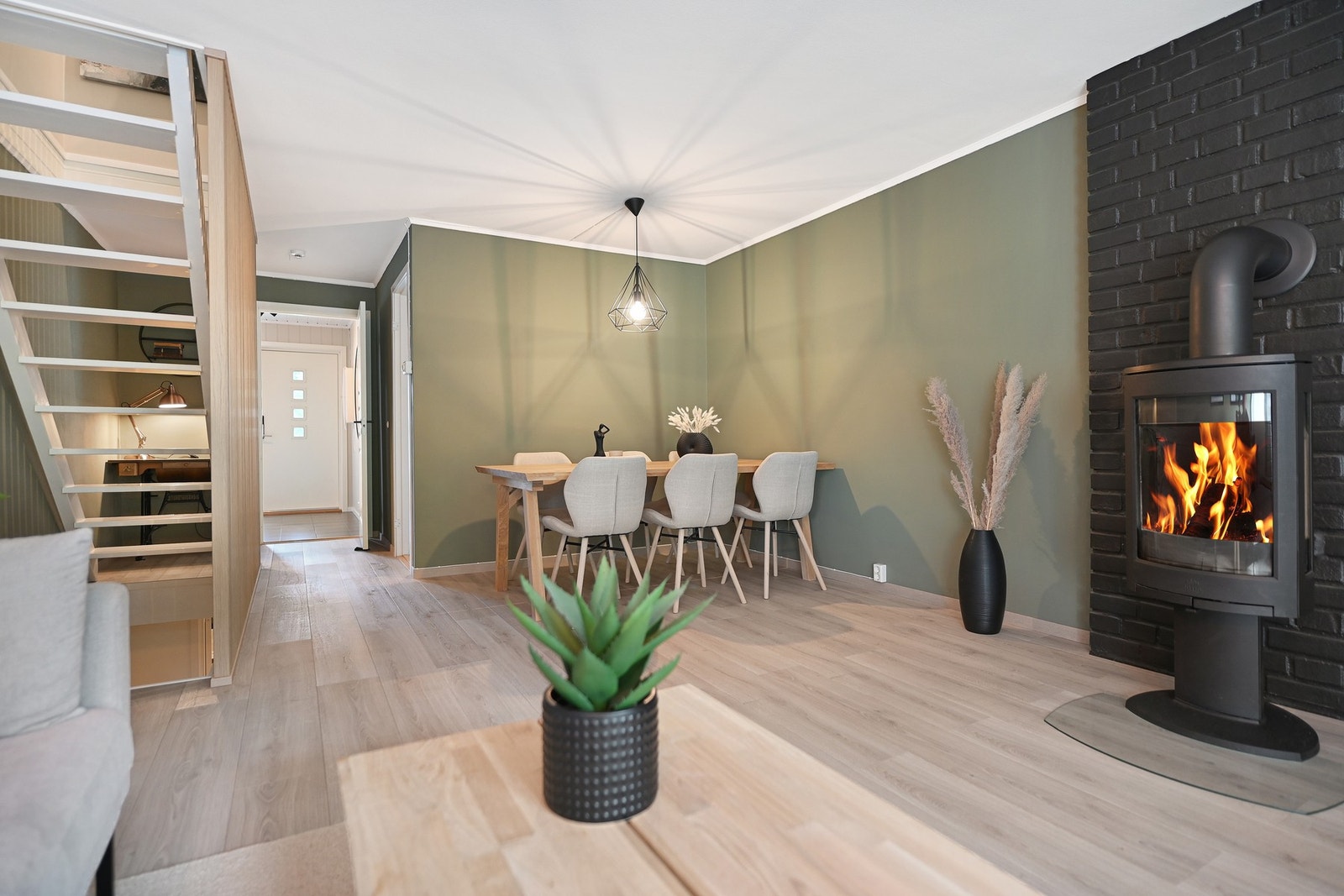 Sentralt i rommet er det vedovn som varmer godt, og gir mye kos og hygge på mørke høst- og vinterkvelder. Galleribilde