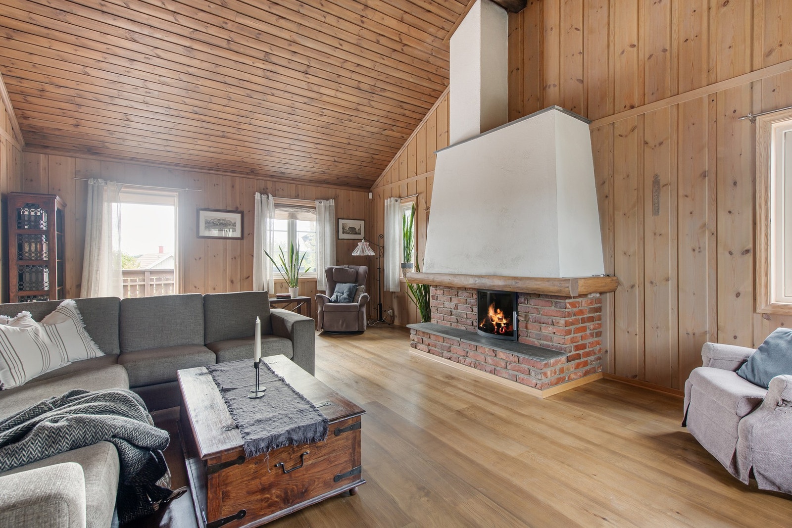 Røff og stilig stue med luftig takhøyde og en bunnsolid peis. Galleribilde