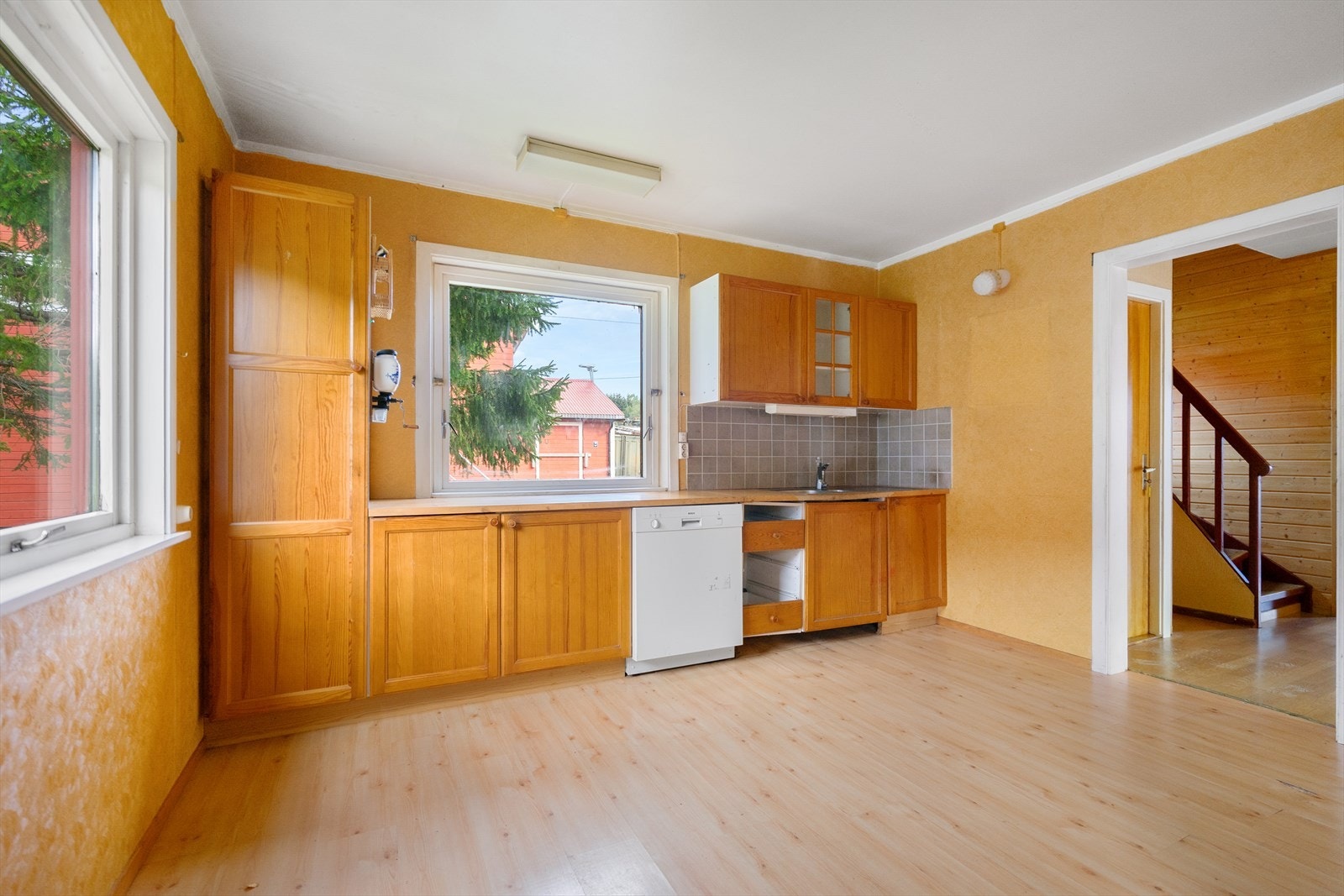 Eldre kjøkken med god planløsning og vinduer på to sider som gir lys og utsikt Galleribilde