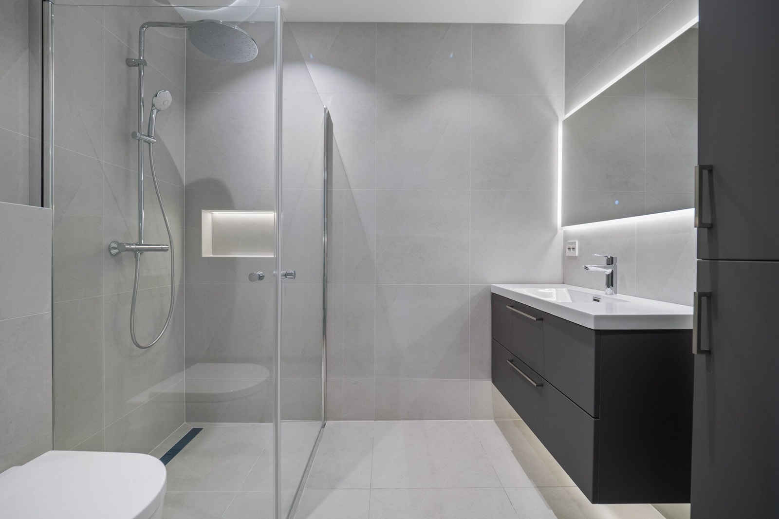 Over den heldekkende servanten er det et store speil med integrert belysning. Galleribilde