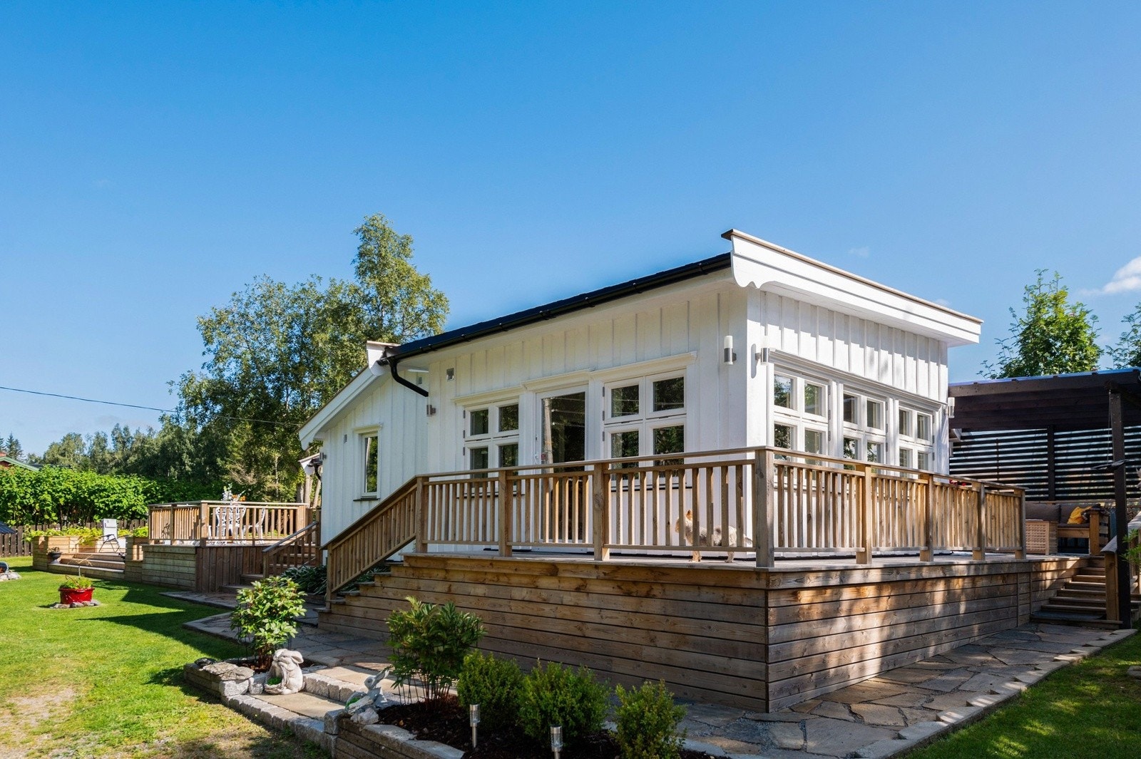 Tomten er parkmessig opparbeidet med gressplen, diverse beplantninger, blomsterbed, vannspeil, gangbro, belegningsstein m.m. Galleribilde