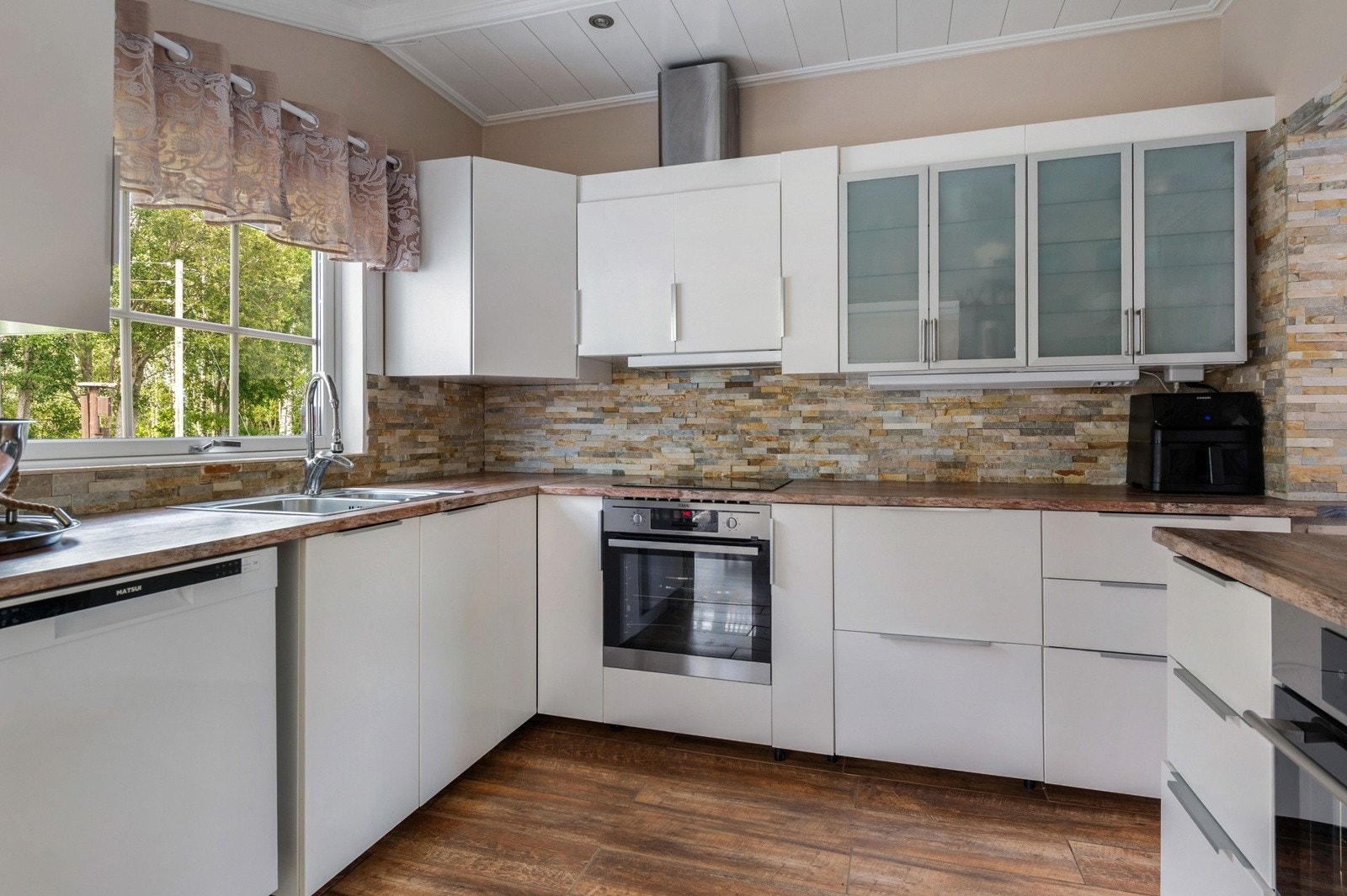 Lys og pen kjøkkeninnredning fra 2020 med god skap- og benkeplass. Galleribilde