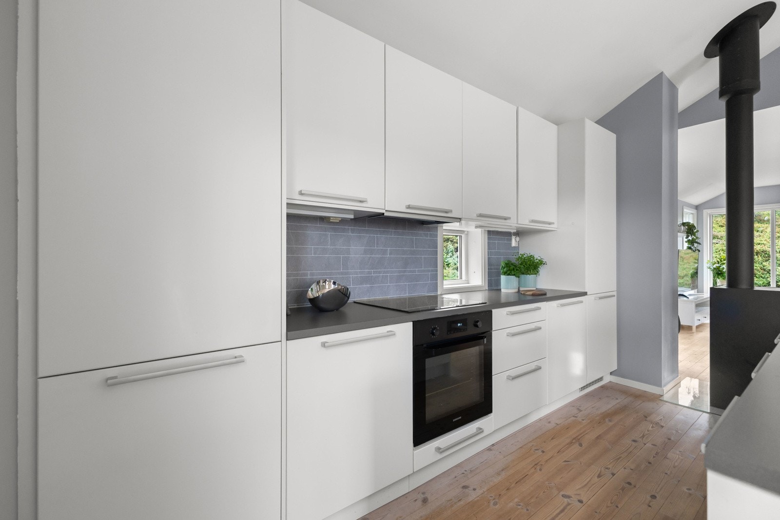 Innredningen har moderne, glatte fronter og praktiske løsninger, med hvitevarer som komfyr, induksjonstopp, kjøleskap og oppvaskmaskin (nytt 2021). Galleribilde