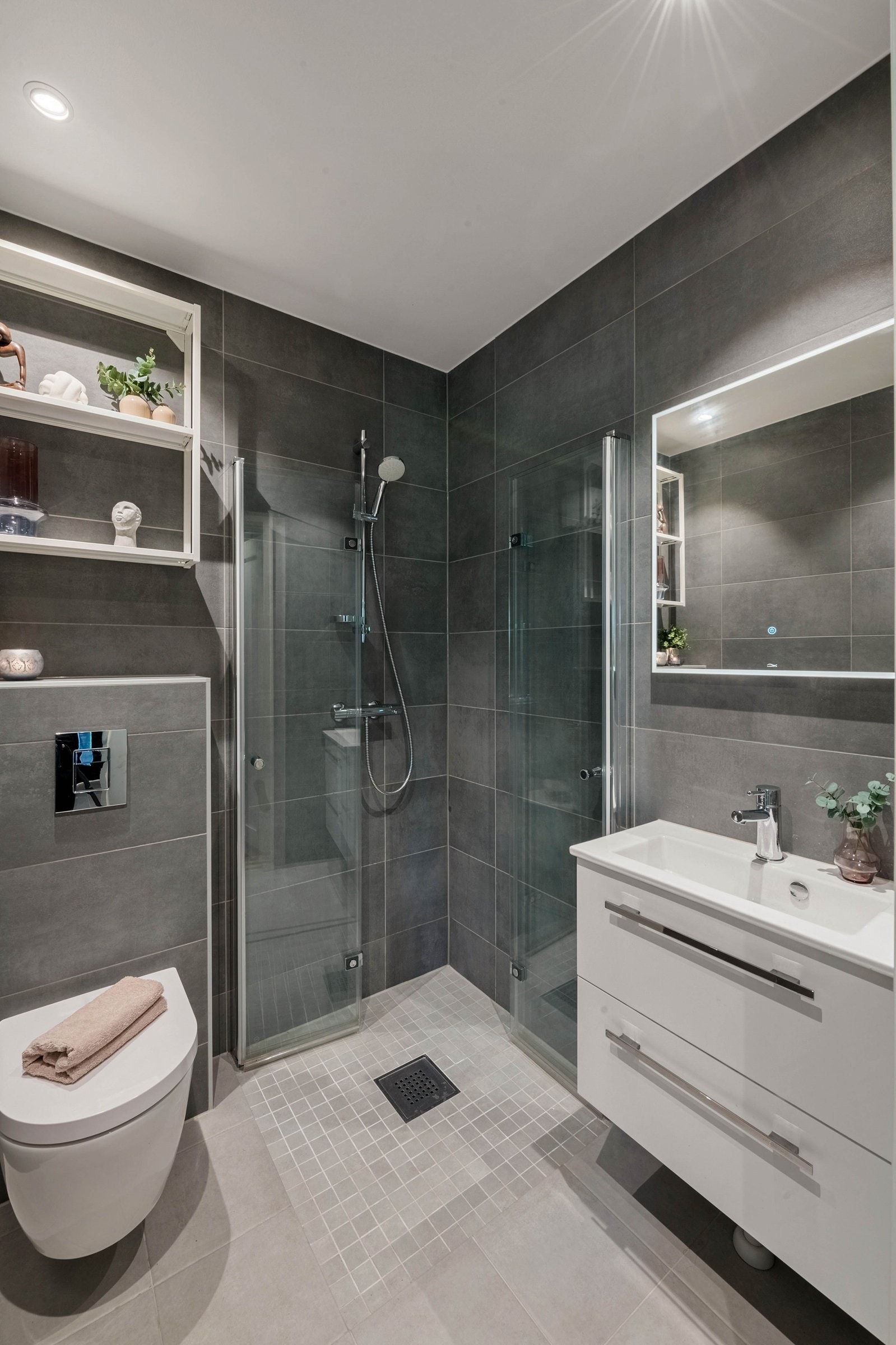 Badet i første etasje har moderne løsninger, som vegghengt toalett, stilrent servantskap med servant, og speil med lys. Galleribilde