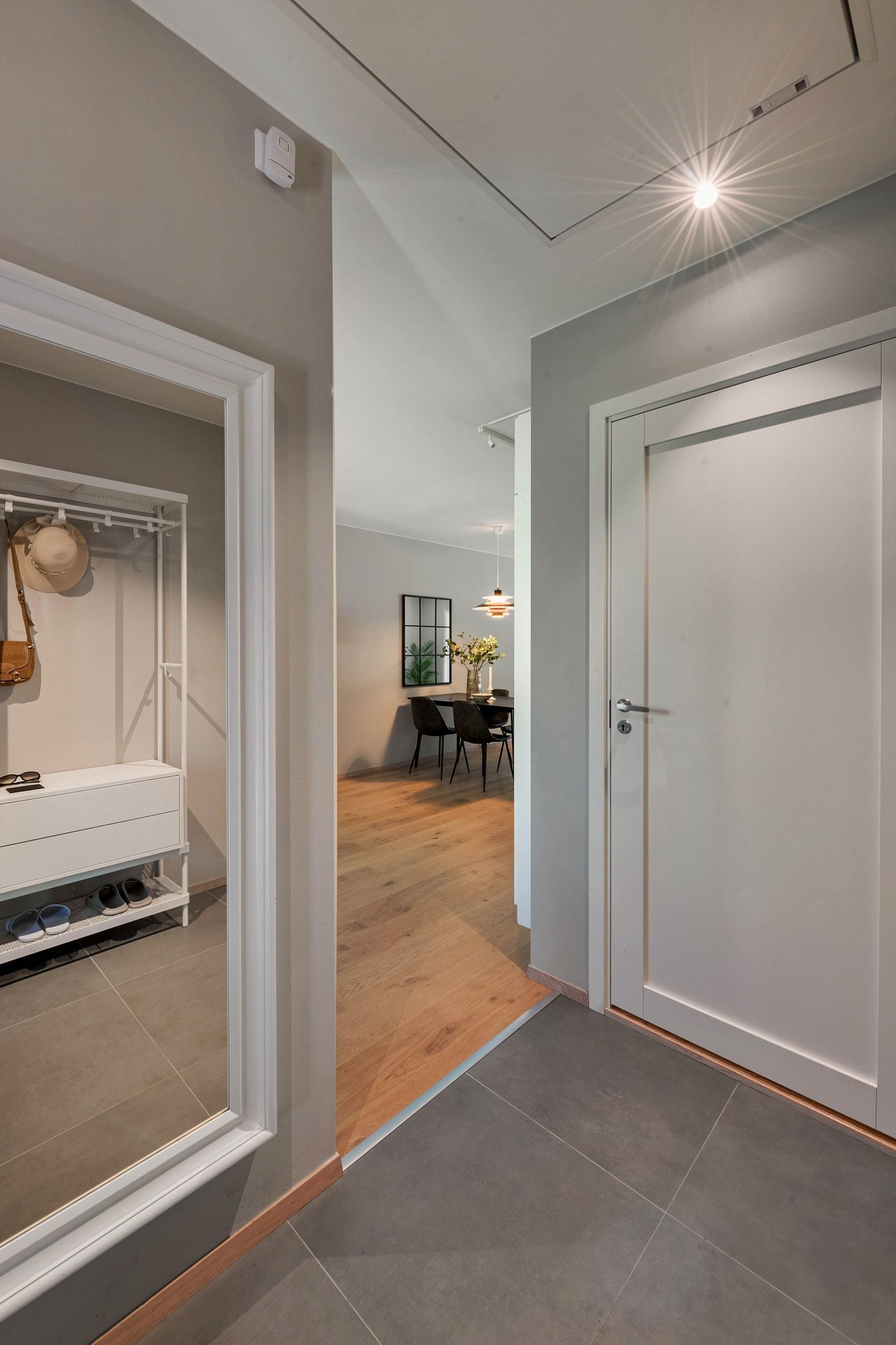 Like ved kjøkkenet og spisestuen ligger den flislagte entréen med gulvvarme og direkte adkomst til et eget bad – praktisk for en travel familie og når man har gjester. Galleribilde