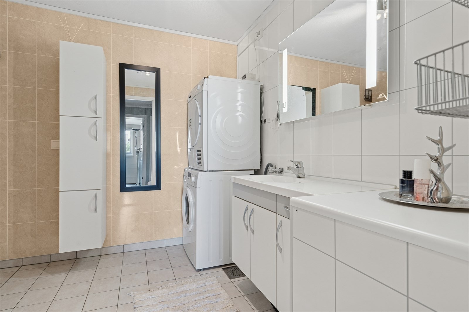 Badet er utført med lyse gulvfliser med elektrisk gulvvarme under og baderomsplater i flisimitasjon på veggene. Galleribilde