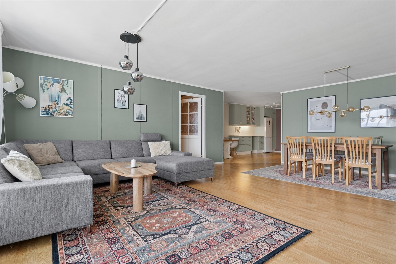 Stuen er utført med et pent laminatgulv og vegger utført i en moderne grønntone. Galleribilde