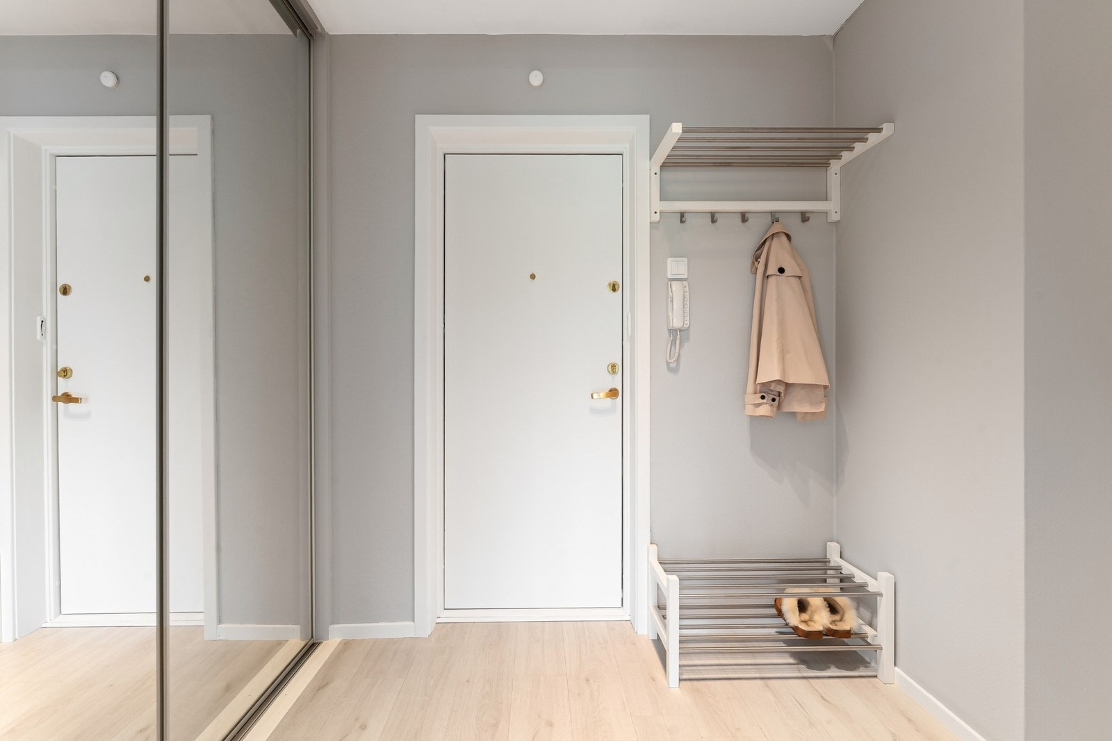 Lys og pen entré med plass for klesoppheng og oppbevaring av sko. Galleribilde