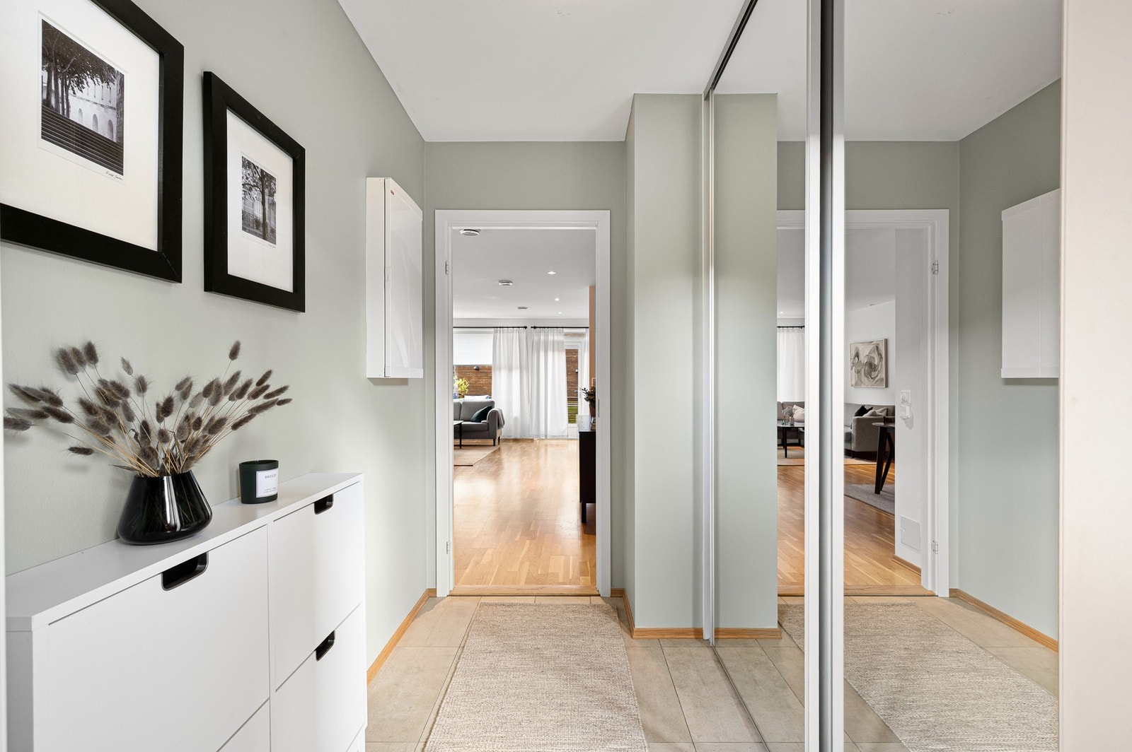 En lys og innbydende flislagt entré ønsker deg velkommen hjem. Her er det godt med oppbevaringsplass i skyvedørsgarderobe. Galleribilde