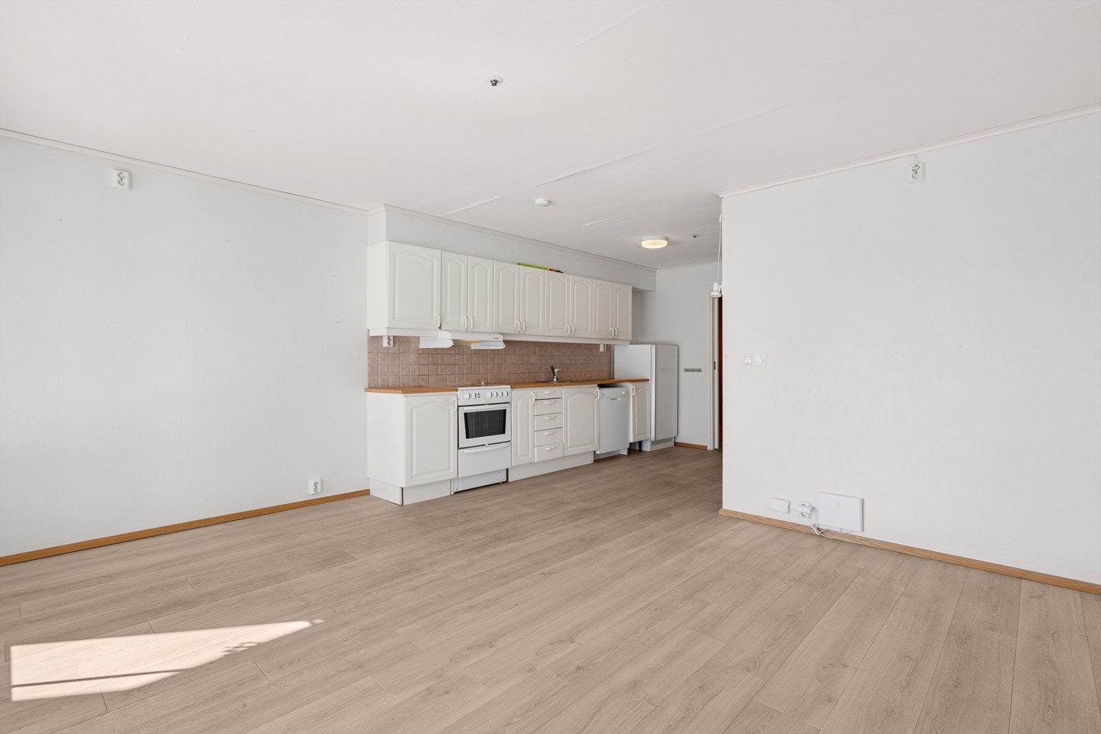 Benkeplaten er i laminat, og veggen over benken er flislagt med lyse, kvadratiske fliser som gir et rent og tidløst uttrykk. Galleribilde