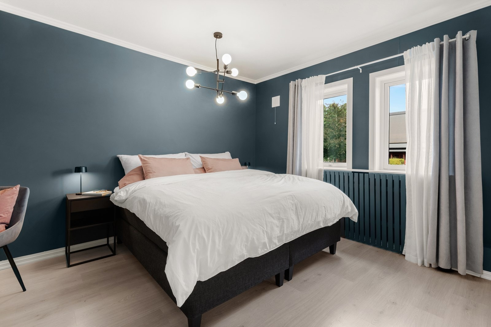 To stilfulle soverom ligger på hver sin side av leiligheten, malt i mørke trendfarger for en lun og avslappende atmosfære. Galleribilde