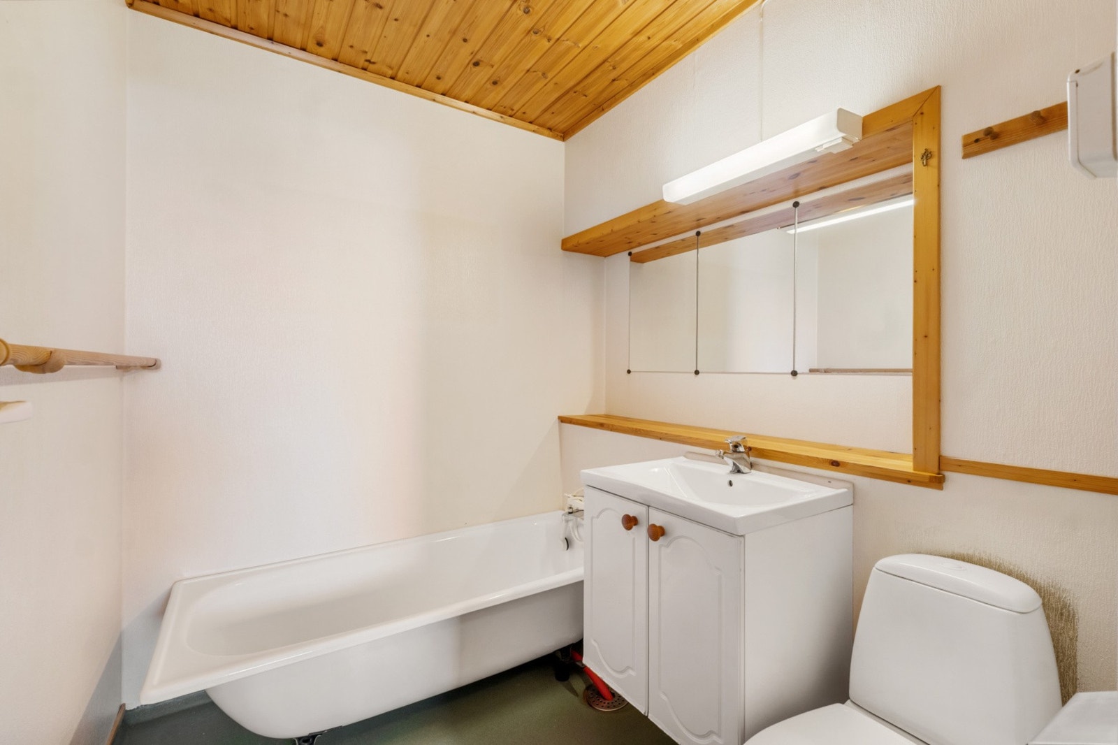 Badet har enkel standard med belegg på gulv, malte vegger og panel i himling, samt innredning med servant, toalett og badekar. Galleribilde