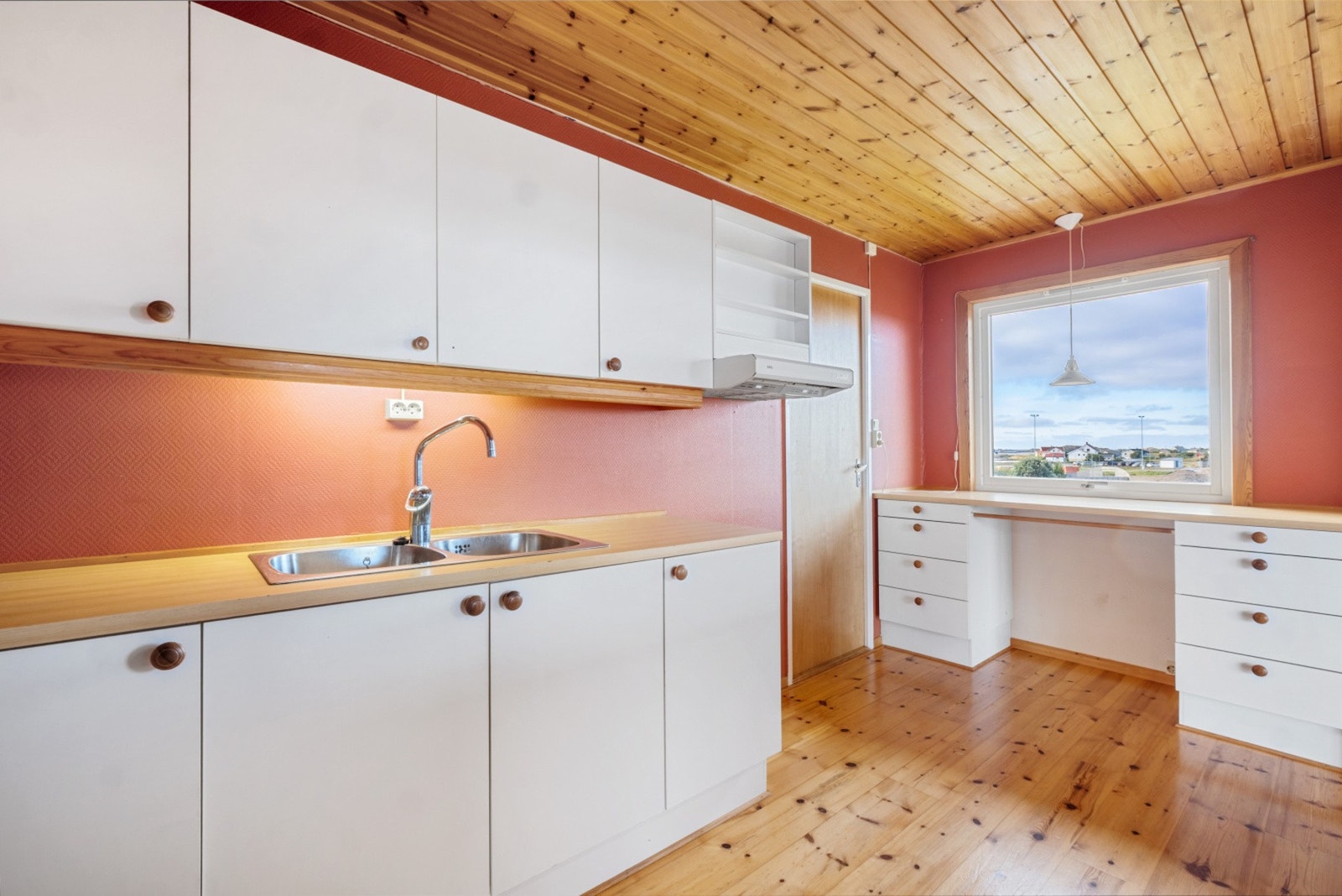 Kjøkkenet har en lys og tidløs innredning med slette, hvite fronter, benkeplate med nedfelt servant og plass for nødvendige hvitevarer som komfyr, kjøleskap og oppvaskmaskin. Galleribilde