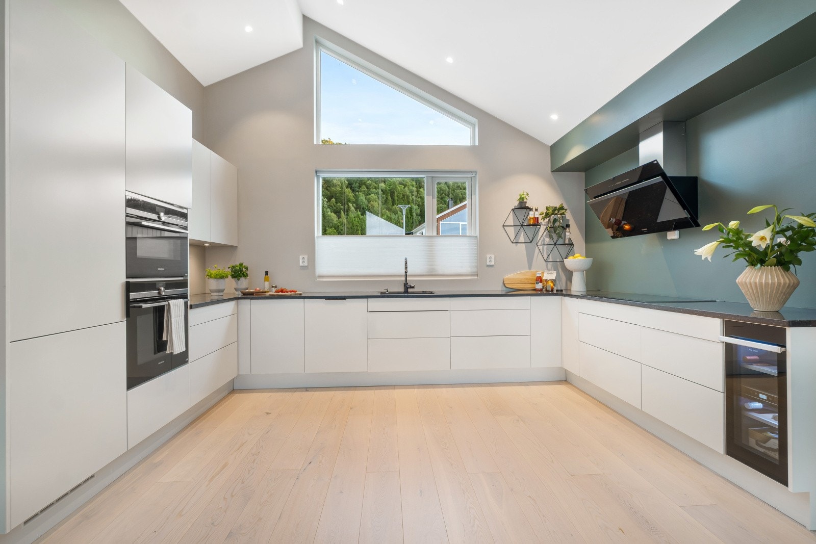 Kjøkkenet er utført med slette hvite fronter og benkeplate i granitt med nedfelt komposittvask Galleribilde