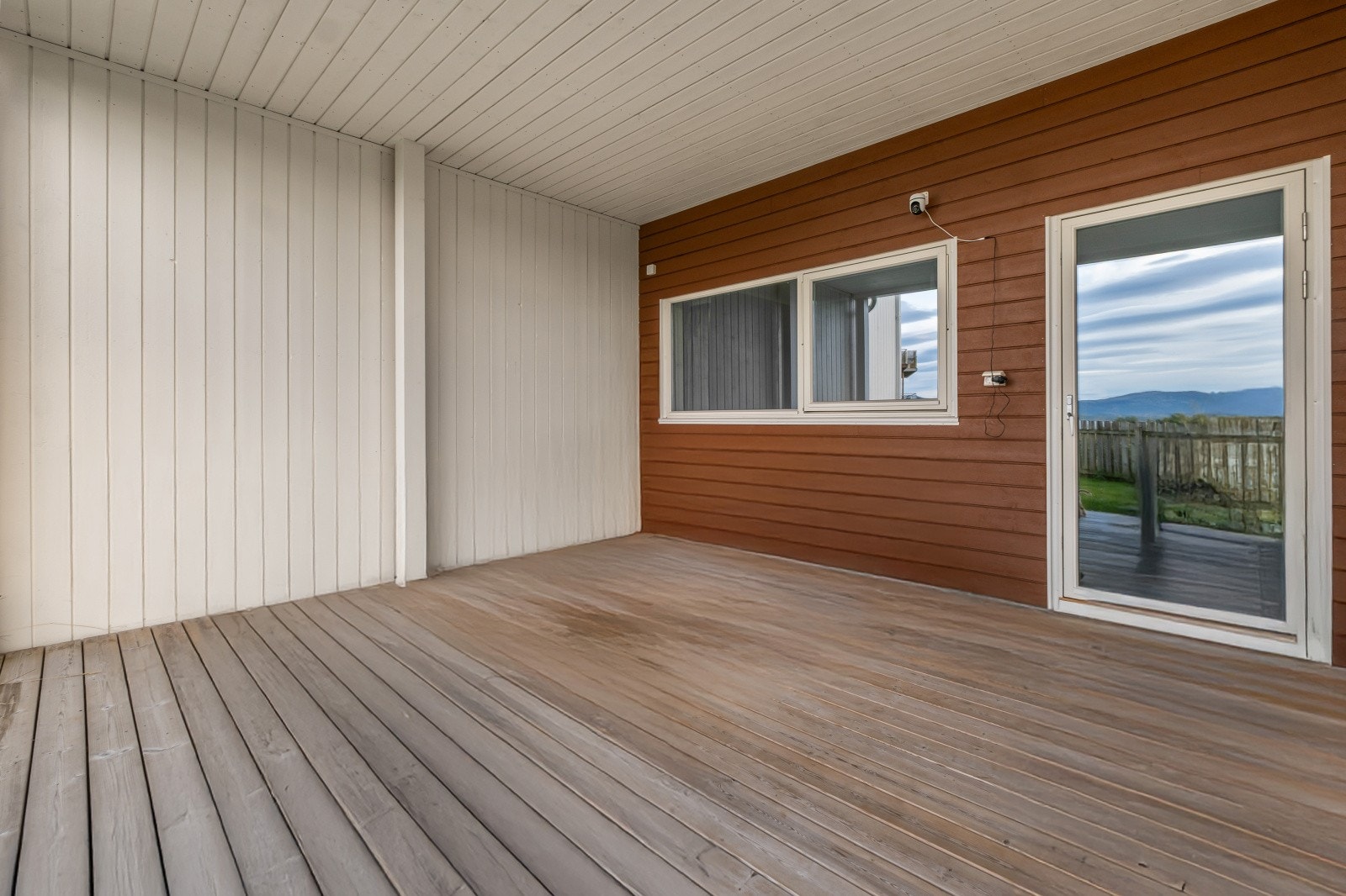 Utgang fra kjellerstuen til en romslig overbygget markterrasse Galleribilde