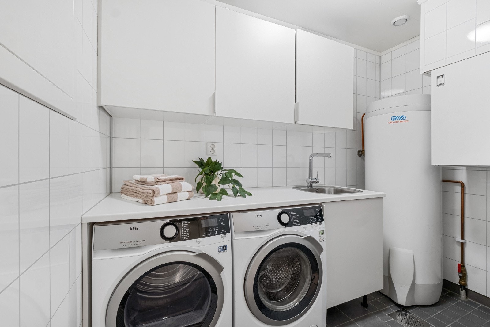 Her finner du innredning med utslagsvask, benkeplate med plass til vaskemaskin/tørketrommel under og overskap Galleribilde